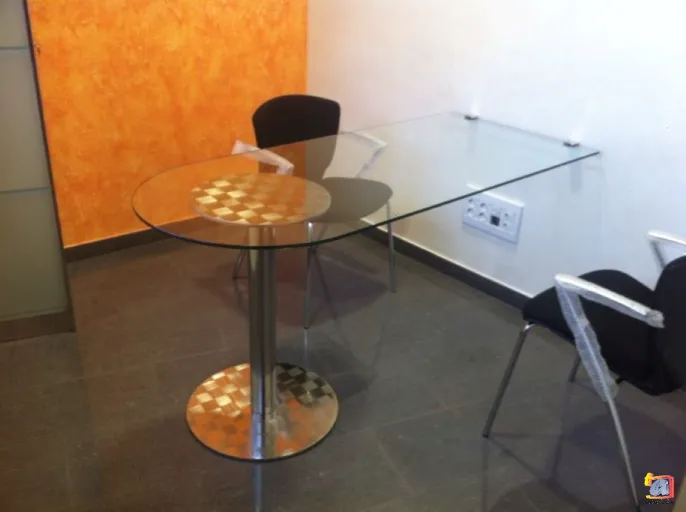 Aluleón - Mesa de vidrio con pata en acero inoxidable.